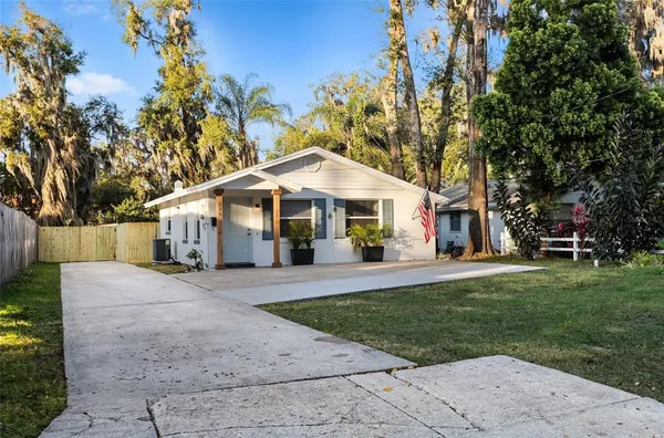a front view of a house with a yard and trees