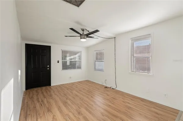a big room with wooden floor and a ceiling fan