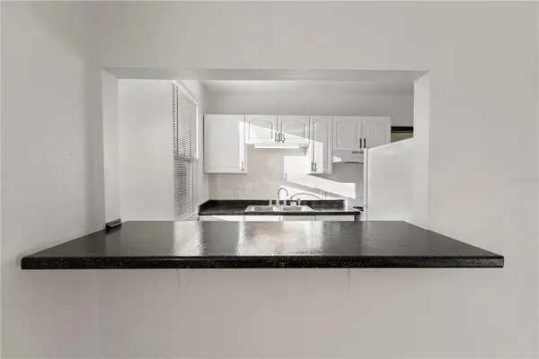 a kitchen with kitchen island a stove a sink and a granite counter tops