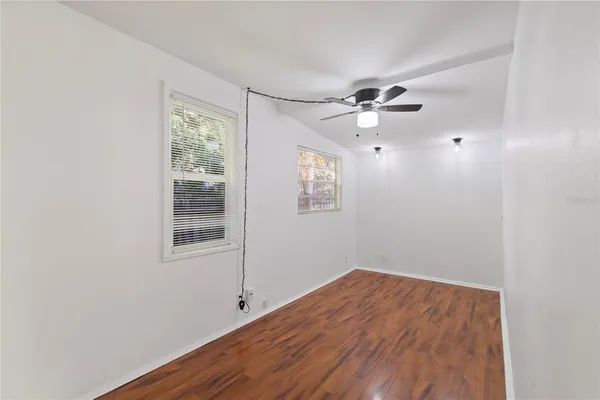 an empty room with fan and windows