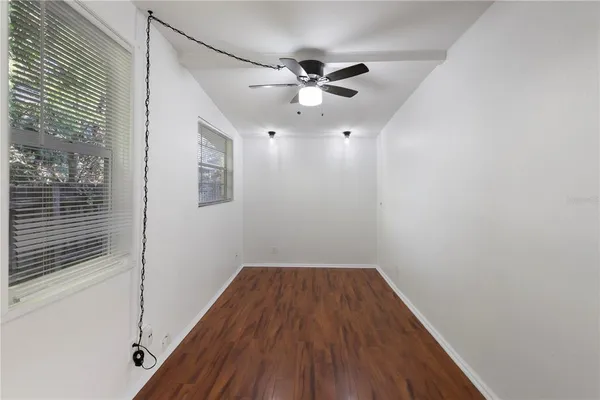 a view of a room with wooden floor and ceiling fan