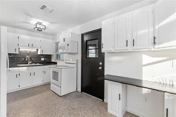a kitchen with cabinets stainless steel appliances and a window