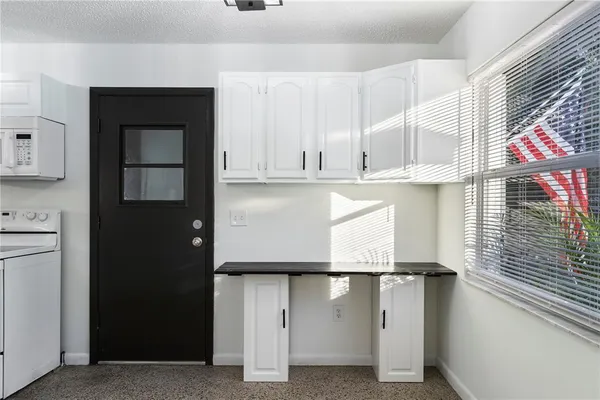 a kitchen with granite countertop white cabinets and refrigerator