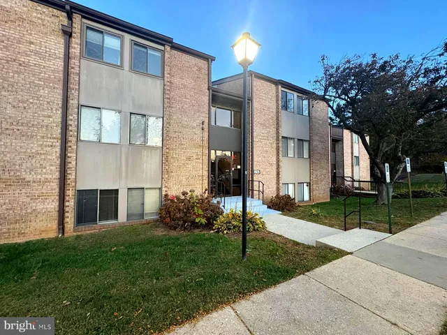 a view of a brick house with a yard and large tree