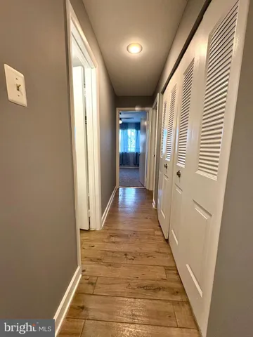 a view of a hallway with wooden floor and staircase