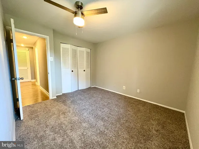 a view of a big room with wooden floor and windows