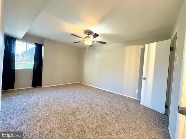 an empty room with closet and a ceiling fan