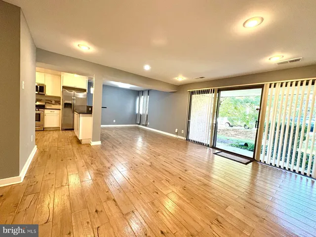 a view of a large kitchen with wooden floor and a kitchen