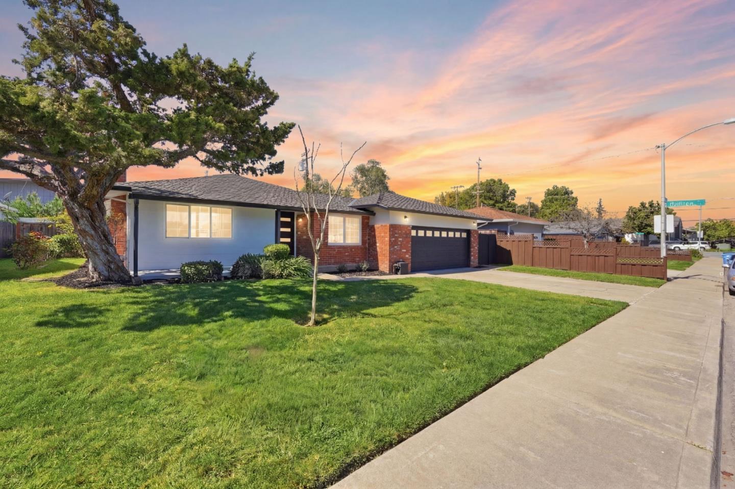 a view of a house with a big yard plants and large trees