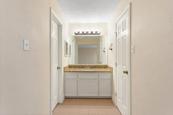 a bathroom with a granite countertop sink and a mirror