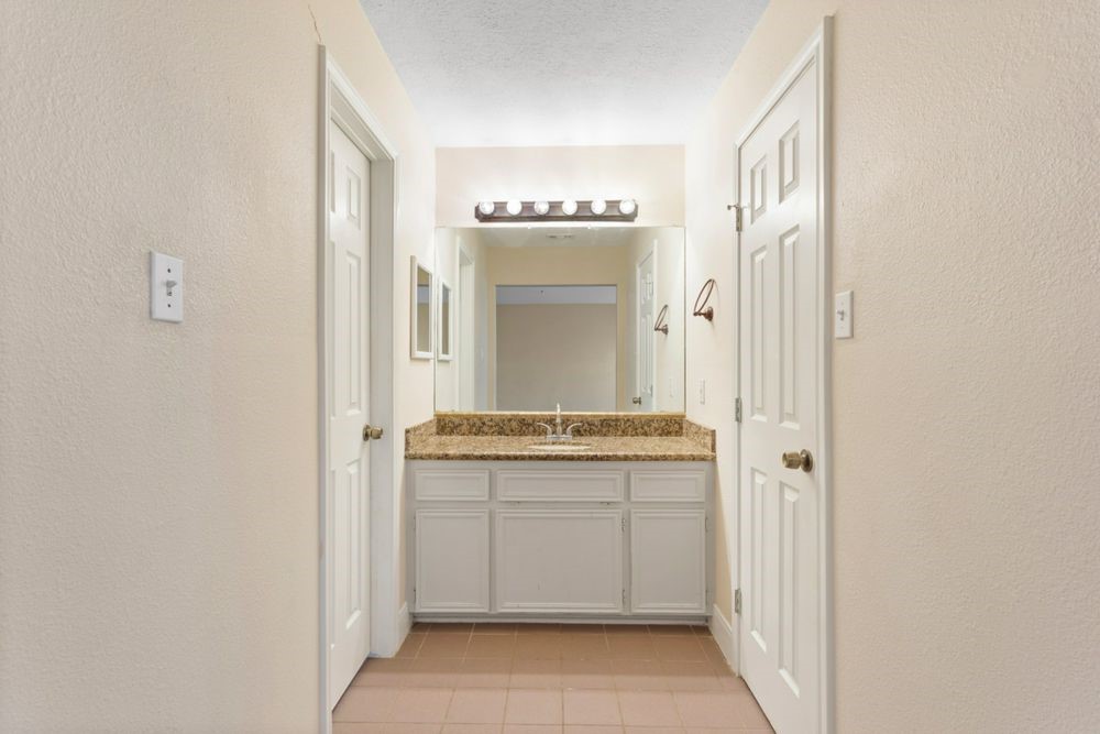 509 Teal Drive Dickinson, TX 77539 - Photo 11 of 23 a bathroom with a granite countertop sink and a mirror