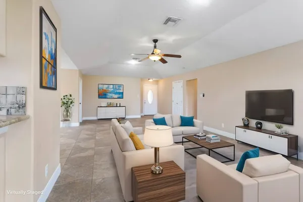 a living room with furniture a flat screen tv and a dining table with wooden floor