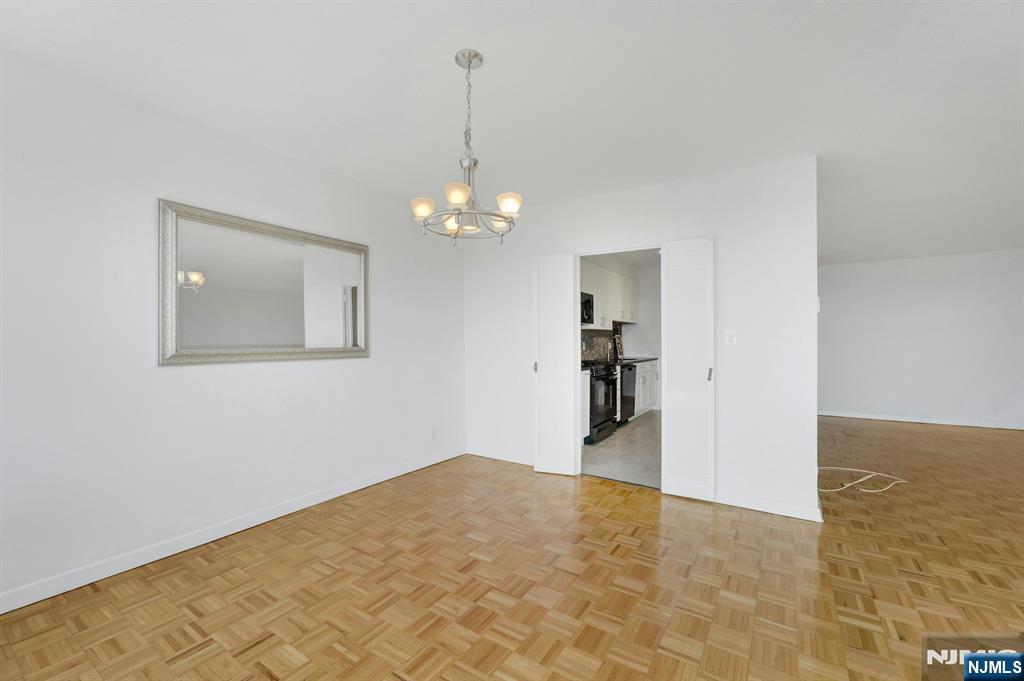 6 Horizon Road, Unit 1508 Fort Lee, NJ 07024 - Photo 24 of 46 a view of a hallway with wooden floor and a chandelier