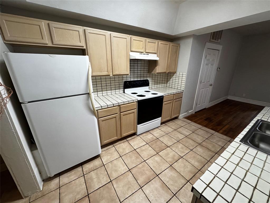 5321 Reiger Avenue, Unit 1 Dallas, TX 75214 - Photo 13 of 18 a kitchen with a refrigerator sink stove and cabinets