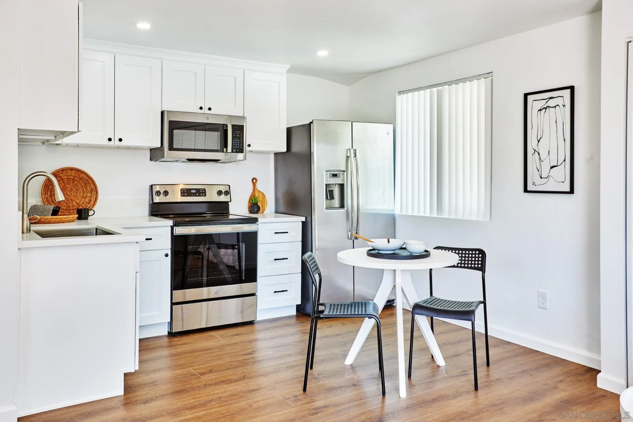 9080 Terrace Drive La Mesa, CA 91941 - Photo 23 of 25 a kitchen with stainless steel appliances a stove a sink refrigerator and white cabinets with wooden floor