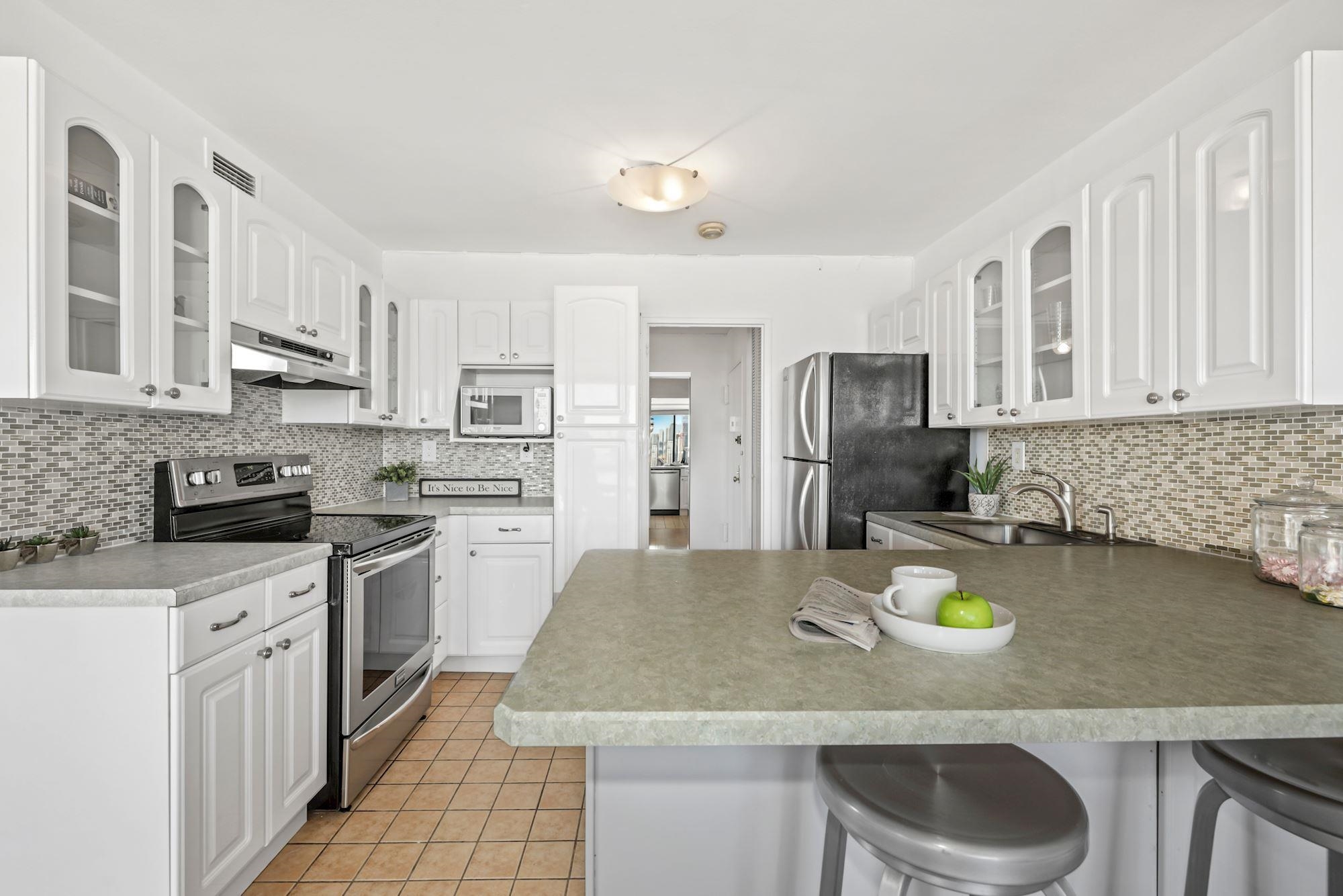 380 Mountain Road, Unit 704 Union City, NJ 07087 - Photo 5 of 21 a kitchen with a sink a stove and chairs