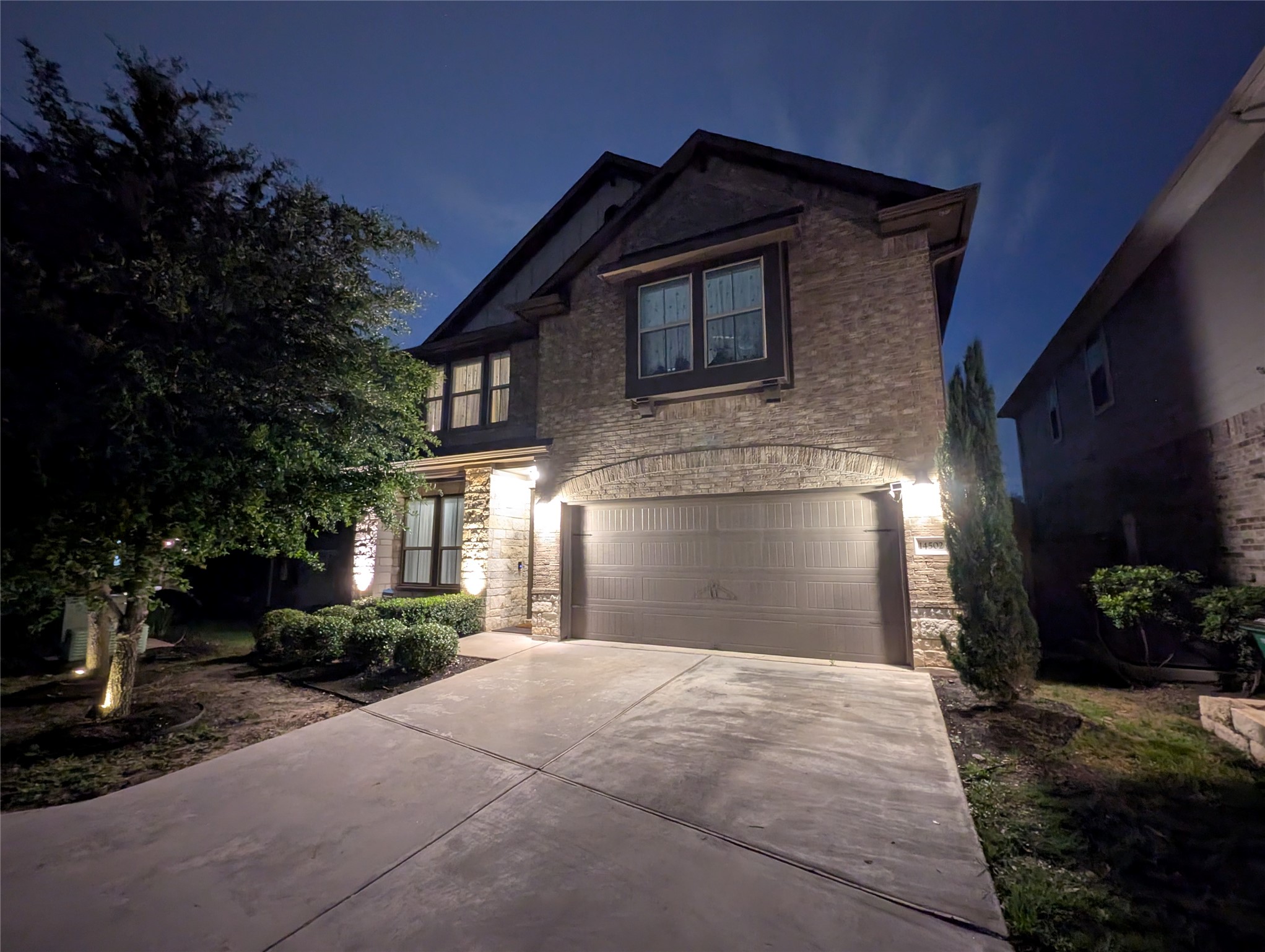 14502 McCoy Loop Austin, TX 78717 - Photo 1 of 26 Brick and stone facade residence featuring a two-car garage with an arched entryway