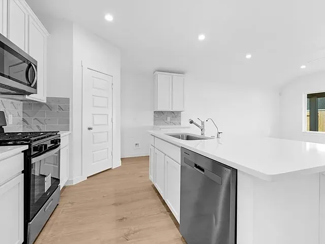 a kitchen with stainless steel appliances a sink stove and cabinets