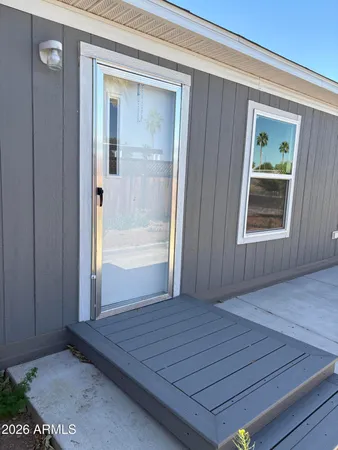 an empty room with wooden floor mirror and windows