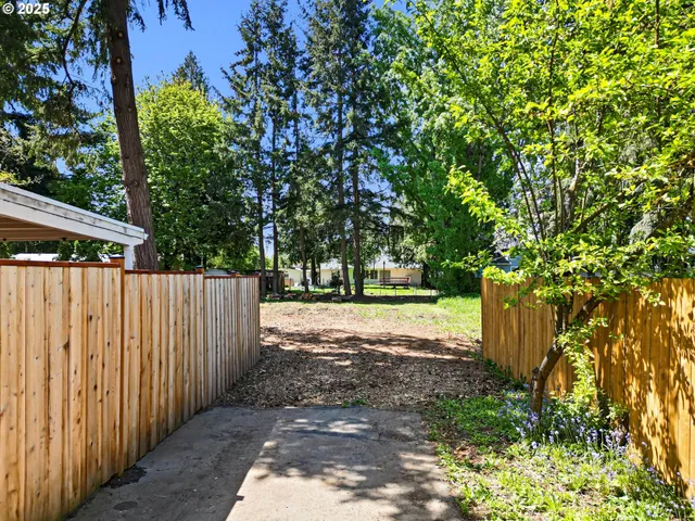 a view of a yard with wooden fence