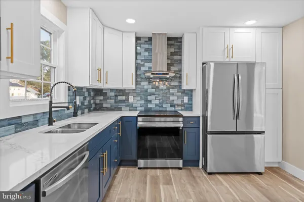 a kitchen with kitchen island granite countertop a sink cabinets and stainless steel appliances