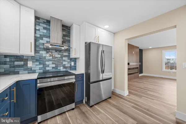 a kitchen with stainless steel appliances granite countertop a refrigerator and a stove top oven
