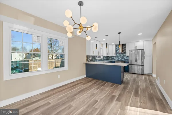 a view of a kitchen with a chandelier fan and wooden floor