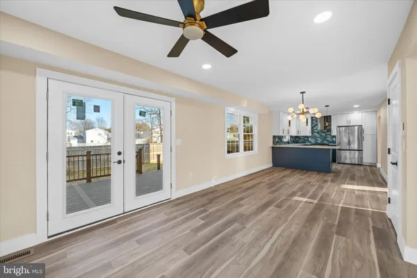 a view of a livingroom with a chandelier fan and kitchen view