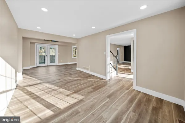 a view of a livingroom with wooden floor and a bathroom