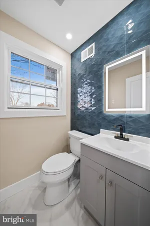 a bathroom with a toilet a sink and mirror