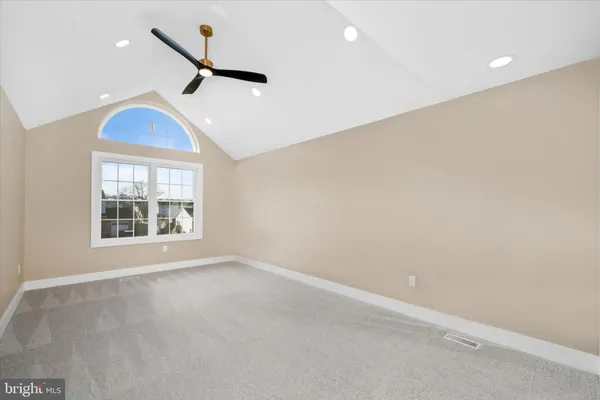 an empty room with windows and ceiling fan