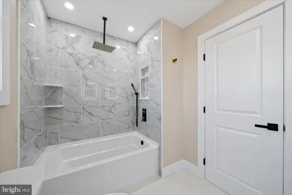 a bathroom with a bathtub a shower and a shower