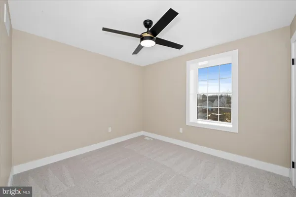 en empty room with ceiling fan and window