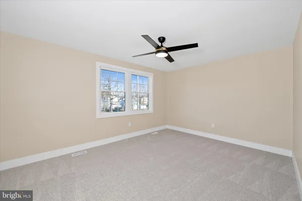 an empty room with a window and a fan