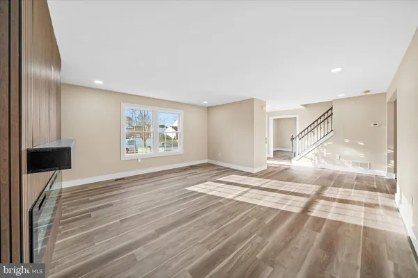 a view of a big room with wooden floor and windows