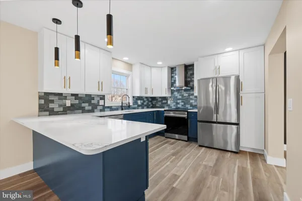 a kitchen with stainless steel appliances a refrigerator and a stove top oven