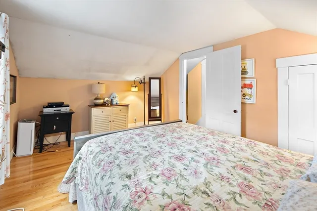 a spacious bedroom with a bed and wooden floor