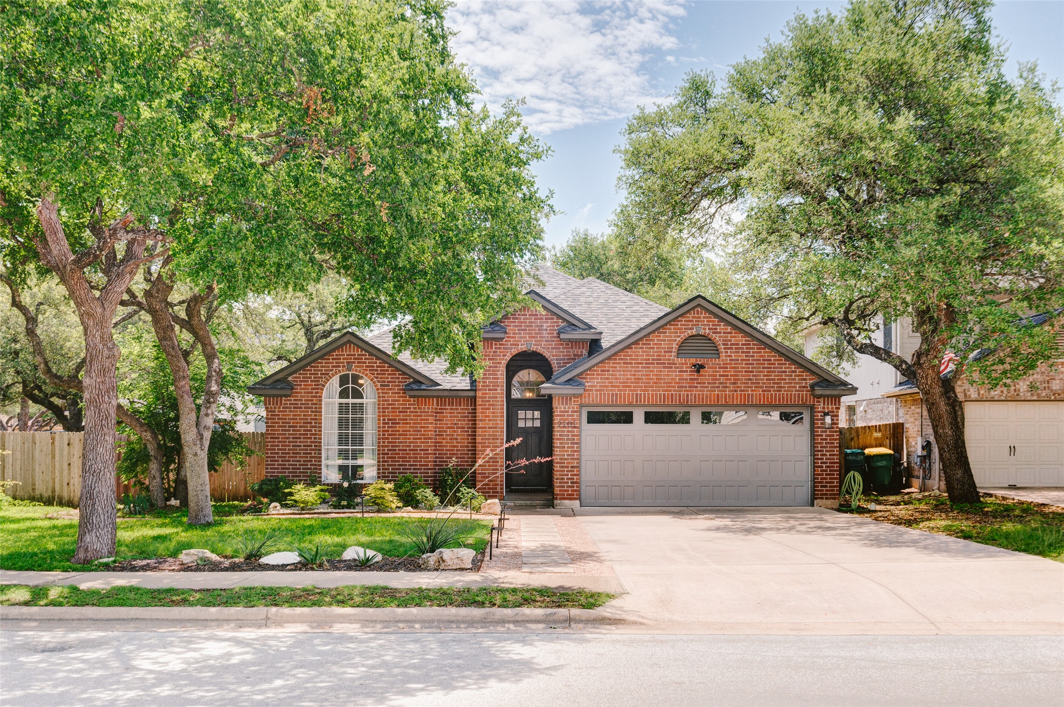 2202 Old Mill Road Cedar Park, TX 78613 - Photo 1 of 23 Mature trees frame this traditional brick residence, offering ample shade and curb appeal.