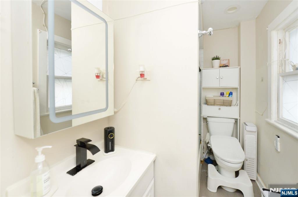 110 3rd Avenue Hawthorne, NJ 07506 - Photo 12 of 17 a bathroom with a sink a toilet and shower curtain