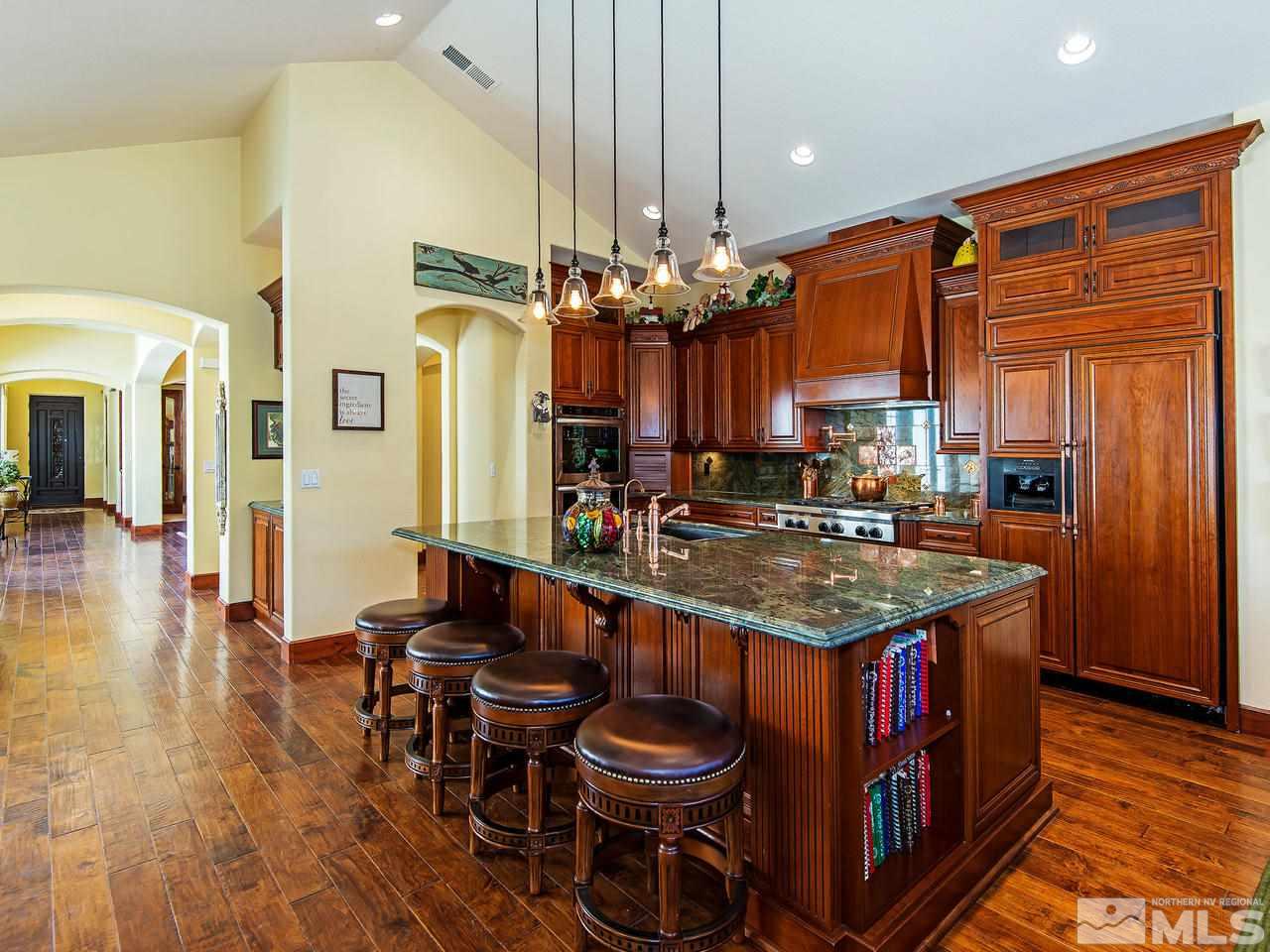 16885 Delacroix Reno, NV 89511 - Photo 8 of 25 a kitchen with stainless steel appliances granite countertop a table chairs and a chandelier
