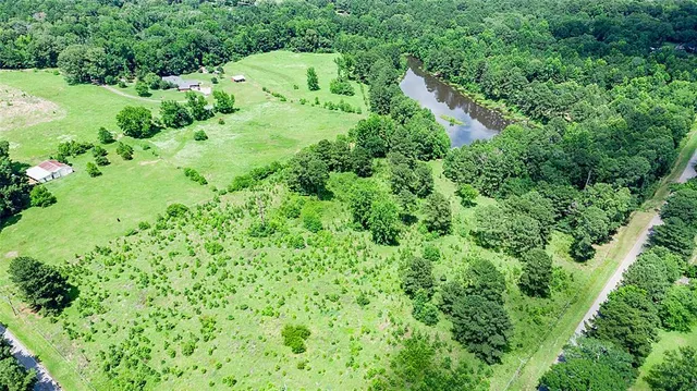 an aerial view of residential house with outdoor space and trees all around