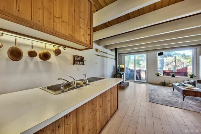 a kitchen with a sink and wooden floor