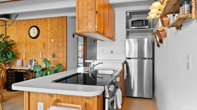 a kitchen with stainless steel appliances granite countertop a sink a refrigerator and a stove