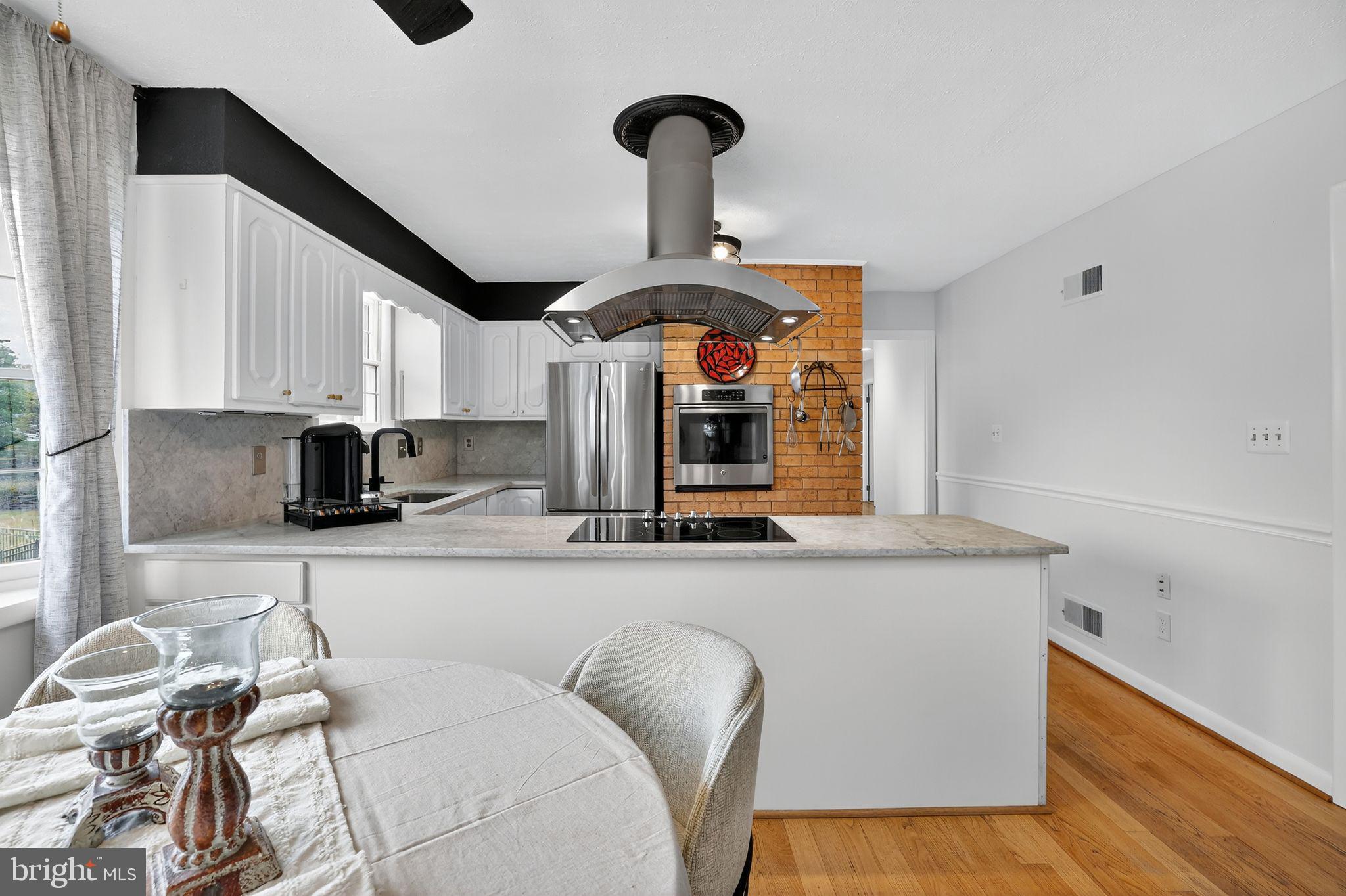 1716 Gayfields Drive Silver Spring, MD 20906 - Photo 24 of 55 a kitchen with stainless steel appliances granite countertop a sink a stove and a wooden floors