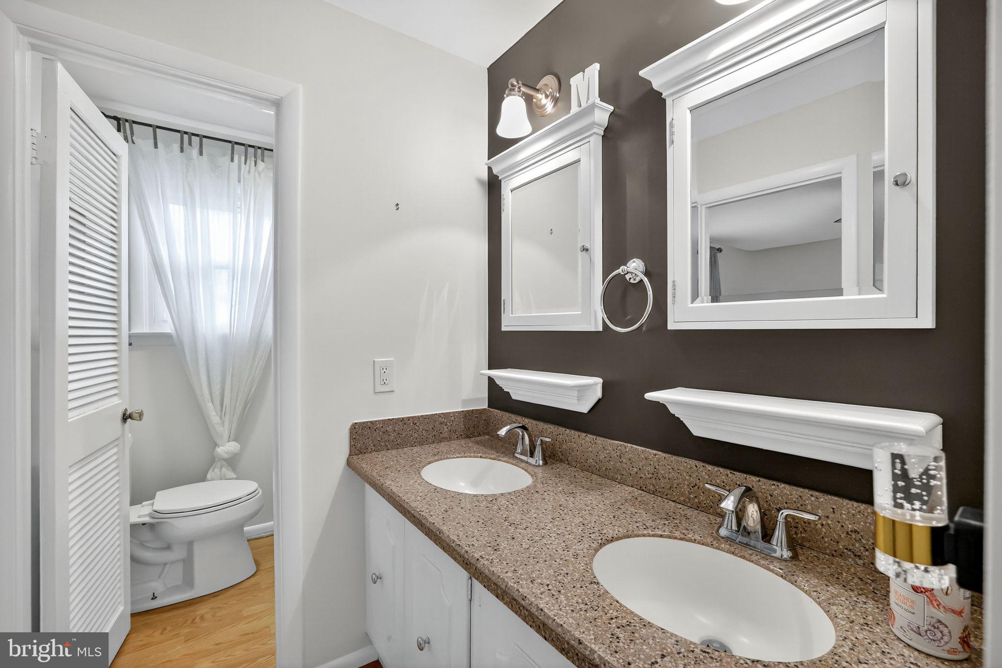 1716 Gayfields Drive Silver Spring, MD 20906 - Photo 33 of 55 a bathroom with a granite countertop sink toilet a mirror and shower