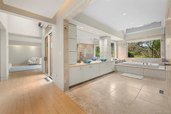 a bathroom with a tub sink shower and mirror
