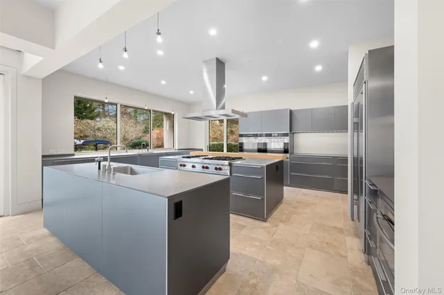 a kitchen with kitchen island a counter top stainless steel appliances and a large window