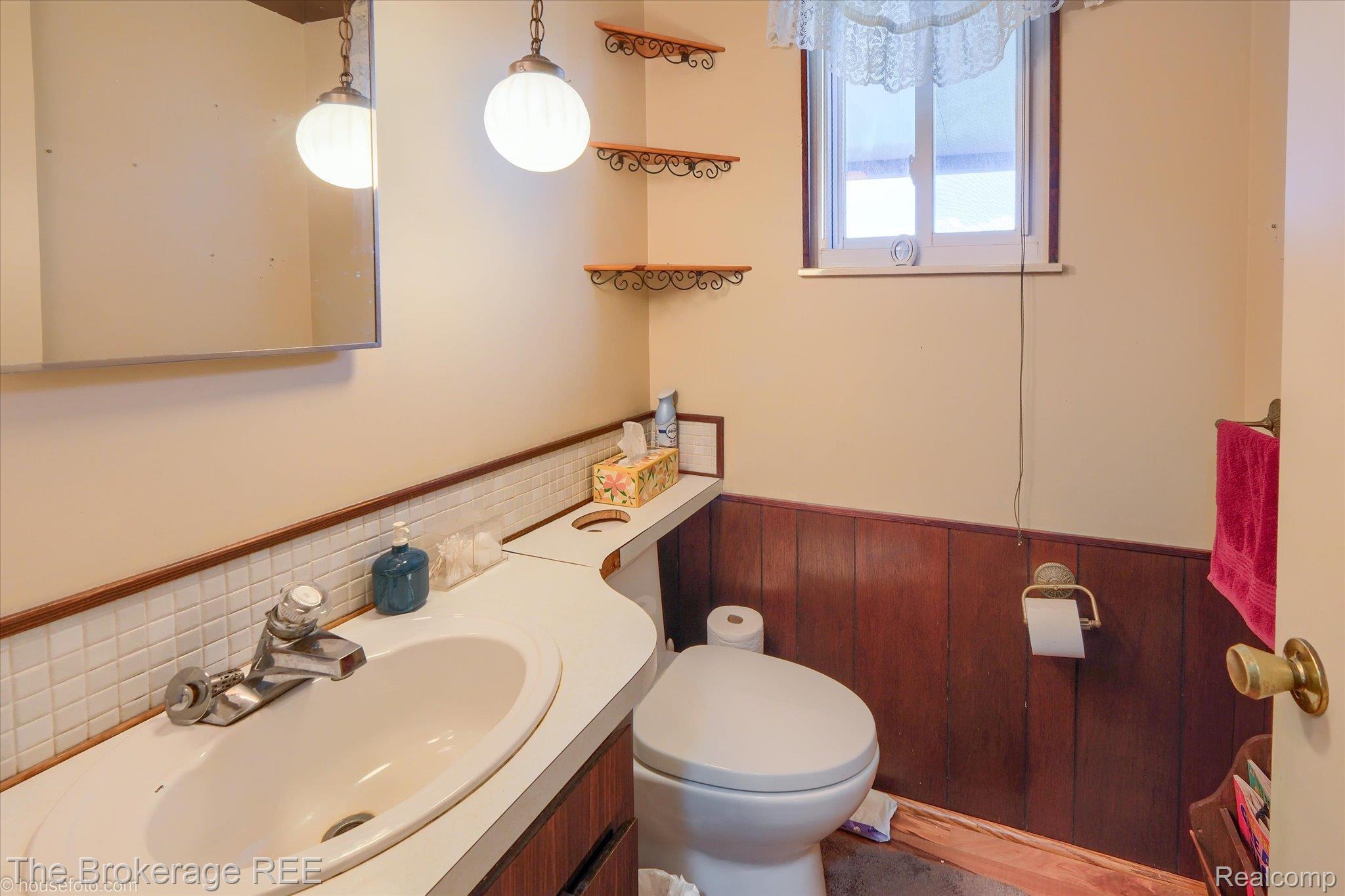 6129 East Lake Road Millington, MI 48746 - Photo 18 of 47 Bathroom featuring wainscoting, vanity, and wooden walls