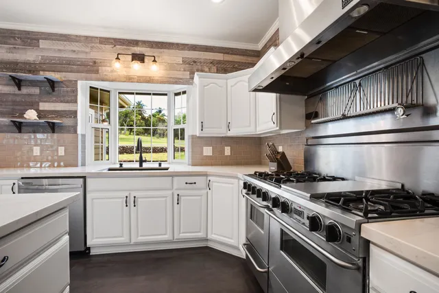 a kitchen with stainless steel appliances granite countertop a stove and a sink