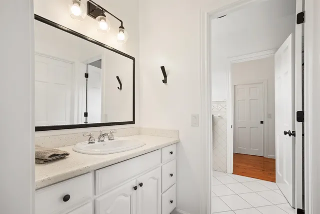 a bathroom with a granite countertop sink and a mirror